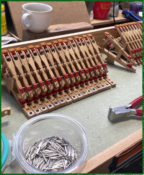 Piano action parts being repaired on a workshop bench